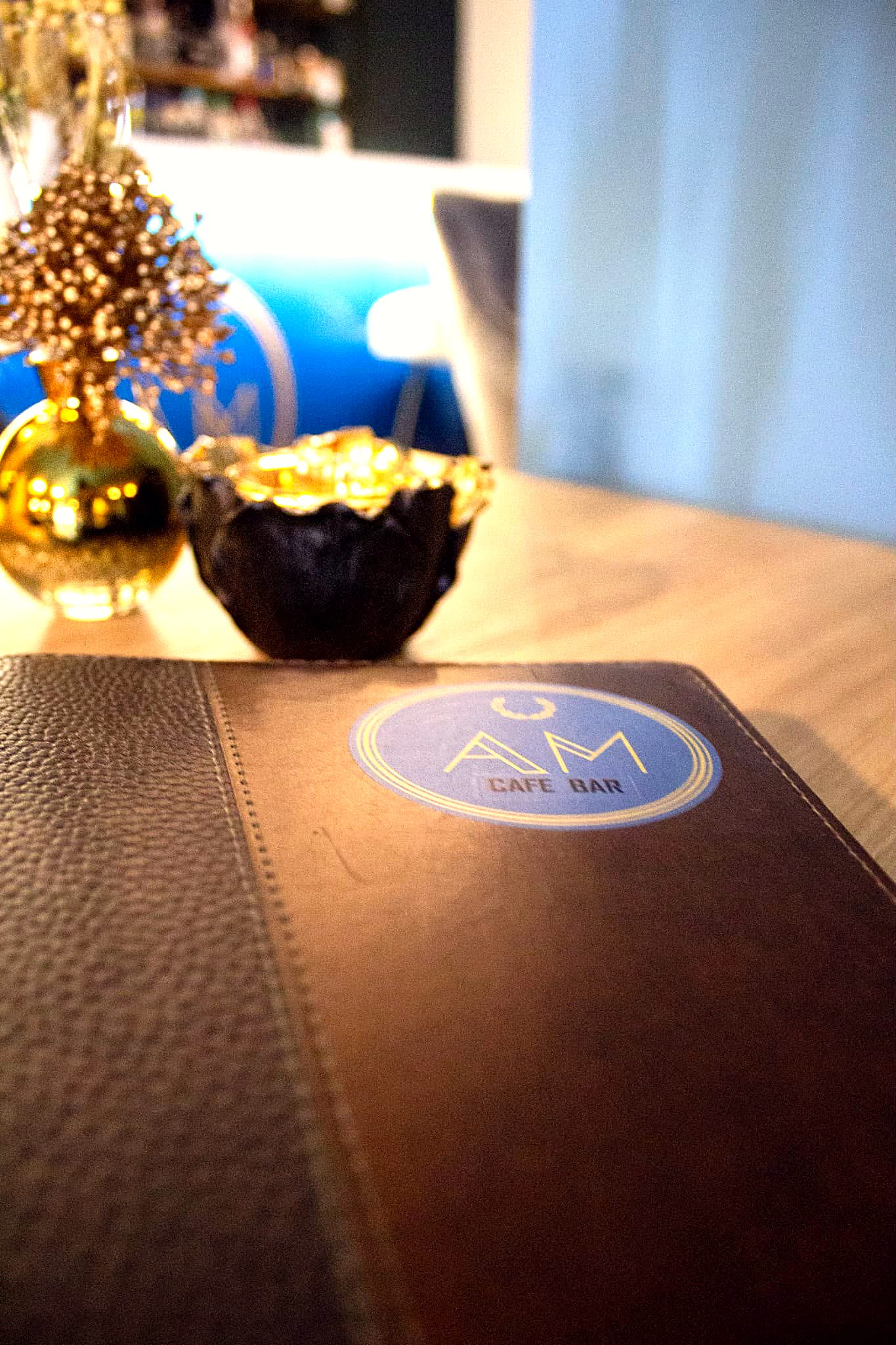 Liebevolles Detail mit Café-AM-Logo auf dem Tisch